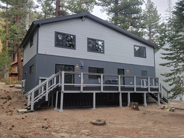 Rear elevation of the new build with a full-width raised deck and steel railings
